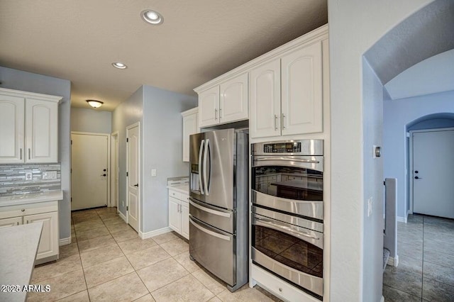 kitchen featuring white cabinetry, light tile patterned floors, stainless steel appliances, and tasteful backsplash