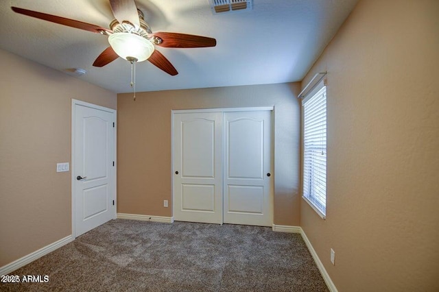 unfurnished bedroom featuring ceiling fan, a closet, and carpet floors