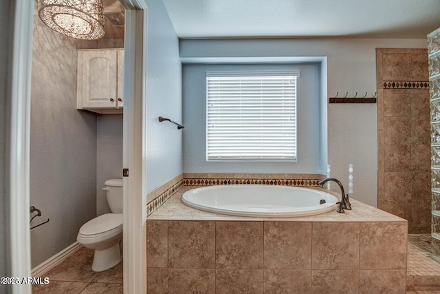 bathroom with toilet, tile patterned floors, and tiled tub