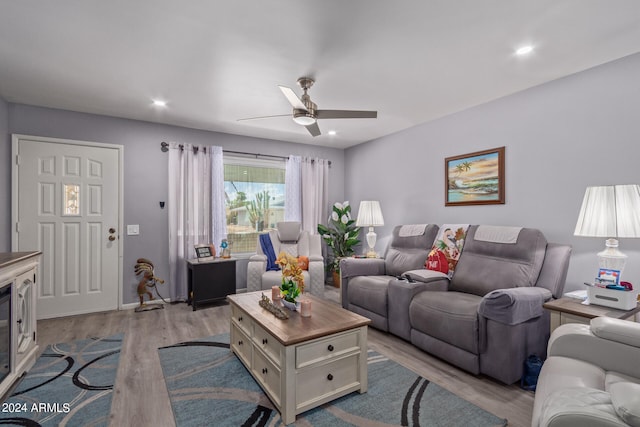 living room with light hardwood / wood-style flooring and ceiling fan