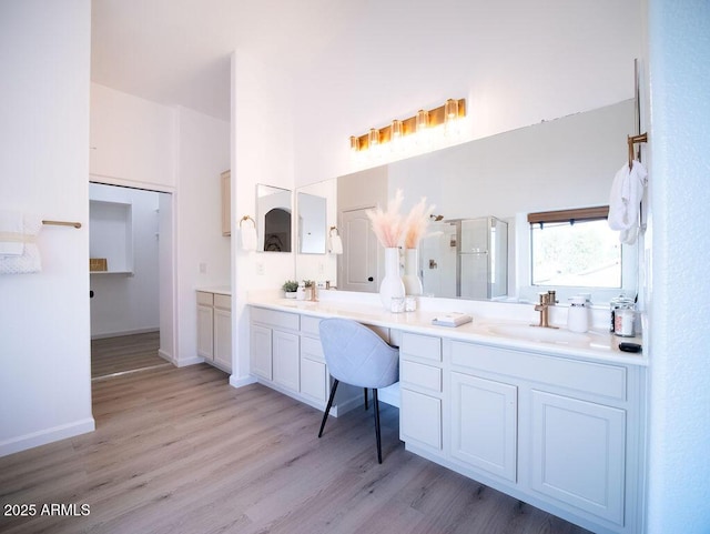 bathroom with vanity, a shower with shower door, and hardwood / wood-style flooring