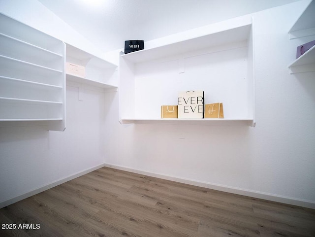 spacious closet with dark hardwood / wood-style flooring