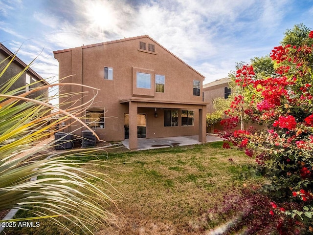 rear view of house featuring a patio and a lawn