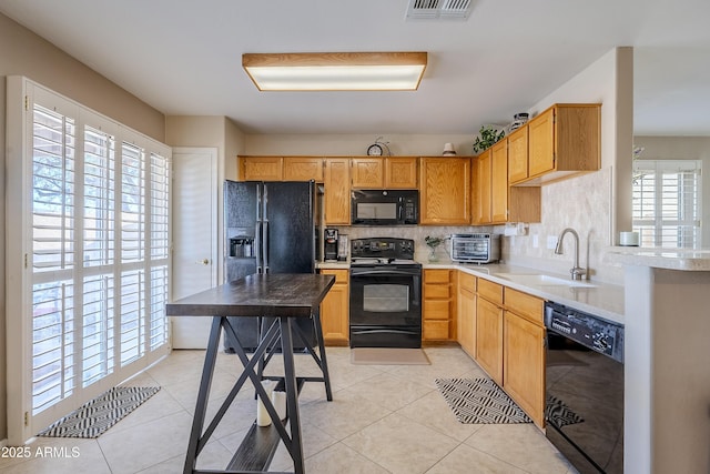 kitchen featuring light tile patterned floors, sink, tasteful backsplash, and black appliances