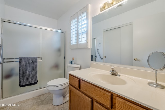 bathroom featuring tile patterned flooring, vanity, toilet, and walk in shower