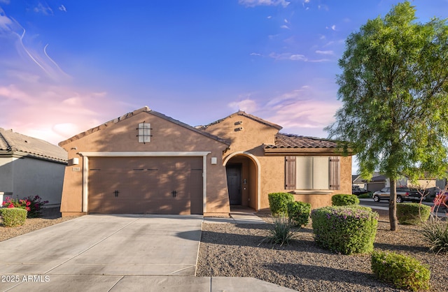 25969 W Tina Ln, Buckeye, AZ 85396 - mediterranean / spanish-style home featuring driveway, stucco siding, an attached garage, and a tiled roof