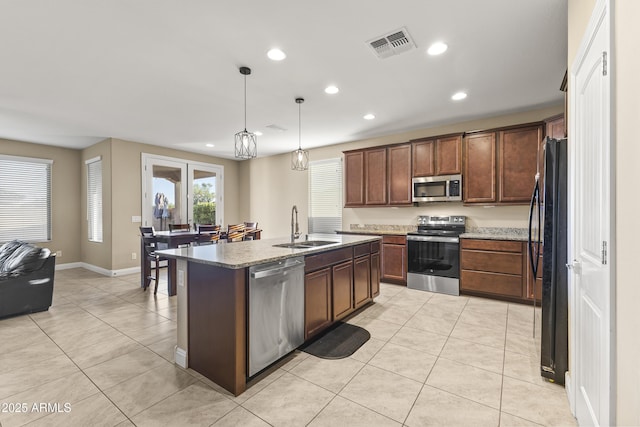 25969 W Tina Ln, Buckeye, AZ 85396 - kitchen featuring stainless steel appliances, recessed lighting, light tile patterned floors, pendant lighting, and a center island with sink