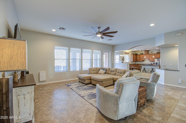 living area with visible vents, arched walkways, baseboards, ceiling fan, and recessed lighting