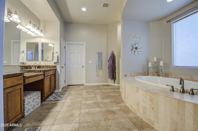 bathroom with tile patterned floors, visible vents, vanity, baseboards, and a bath