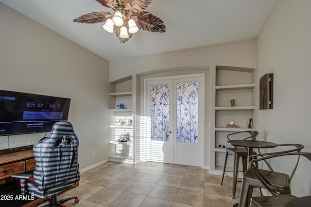 interior space with baseboards, a ceiling fan, and tile patterned floors