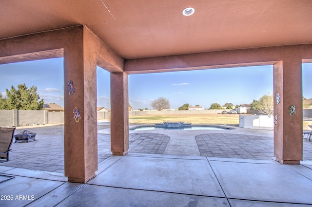 view of patio featuring an outdoor pool, fence, and a hot tub