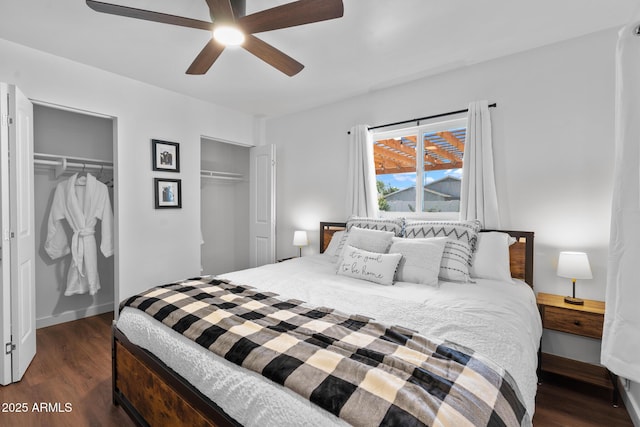 bedroom featuring dark wood-type flooring, ceiling fan, and two closets