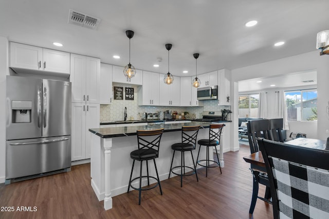 kitchen with dark wood-type flooring, appliances with stainless steel finishes, sink, and white cabinets