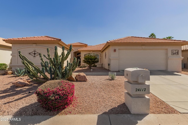 mediterranean / spanish-style house featuring a tile roof, driveway, an attached garage, and stucco siding