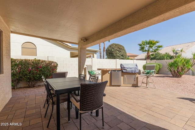 view of patio with outdoor dining area, a fenced backyard, and a grill