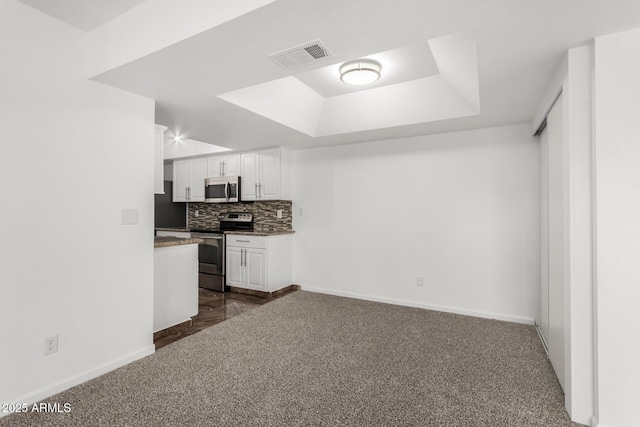 714 E Morningside Dr, Phoenix, AZ 85022 - kitchen with dark colored carpet, stainless steel appliances, a raised ceiling, visible vents, and white cabinets