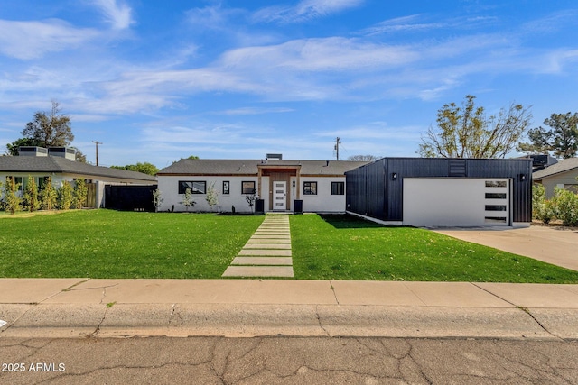 view of front of home with a garage, concrete driveway, and a front lawn