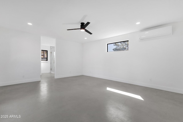 empty room featuring recessed lighting, baseboards, concrete flooring, and an AC wall unit