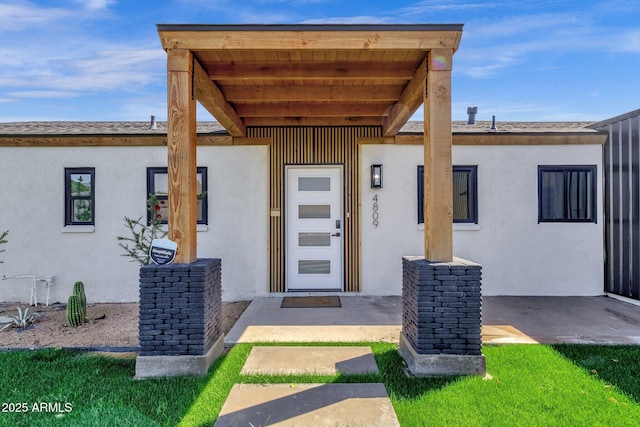 view of exterior entry with stucco siding