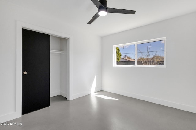 unfurnished bedroom featuring a closet, baseboards, finished concrete floors, and a ceiling fan