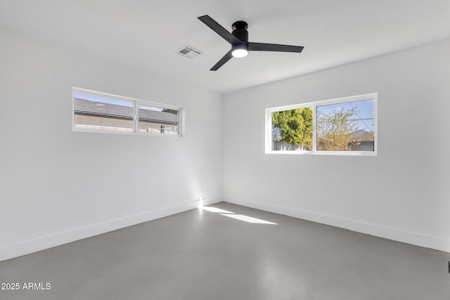 unfurnished room featuring visible vents, finished concrete flooring, baseboards, and a ceiling fan