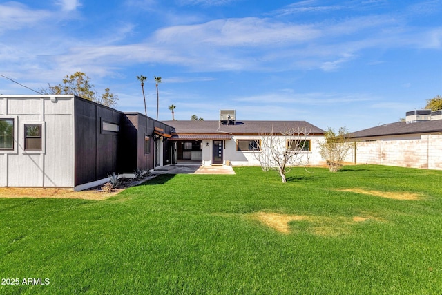 back of house featuring a patio and a lawn