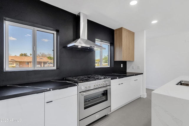 kitchen featuring modern cabinets, finished concrete flooring, recessed lighting, stainless steel stove, and wall chimney range hood