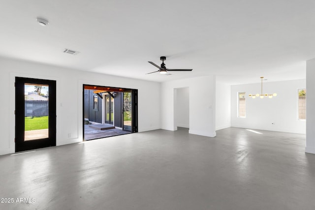 unfurnished room with visible vents, ceiling fan with notable chandelier, and concrete flooring