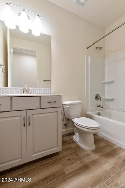 full bathroom with hardwood / wood-style floors, vanity, toilet, and shower / tub combination