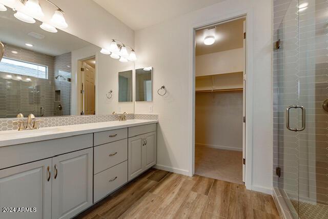 bathroom with vanity, an enclosed shower, and wood-type flooring