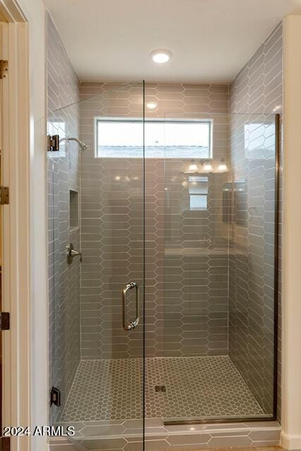 bathroom featuring a shower with door and plenty of natural light