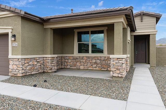 property entrance with covered porch and a garage