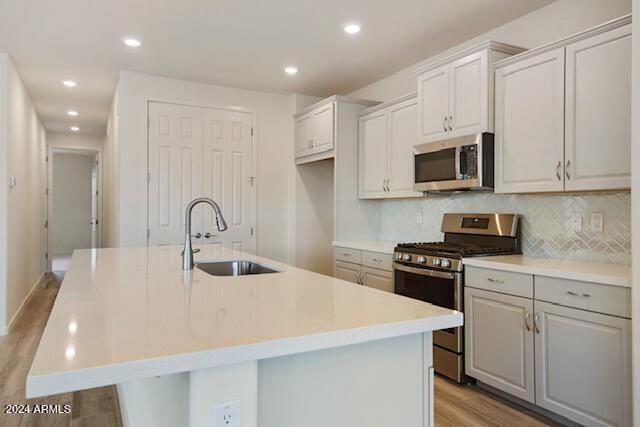 kitchen featuring sink, a center island with sink, and appliances with stainless steel finishes