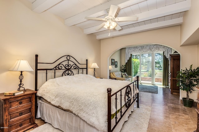 bedroom featuring arched walkways, beam ceiling, access to exterior, and a ceiling fan