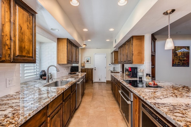 kitchen with light stone counters, recessed lighting, appliances with stainless steel finishes, and a sink