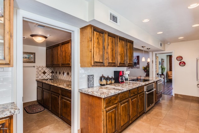 kitchen featuring visible vents, a sink, oven, black electric stovetop, and tasteful backsplash