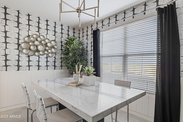 dining room featuring wainscoting and an inviting chandelier