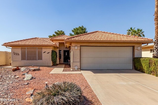 mediterranean / spanish home with driveway, an attached garage, a tiled roof, and stucco siding