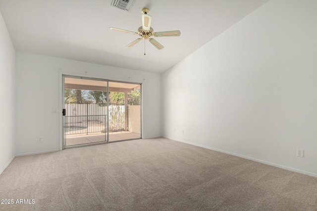 carpeted spare room with a ceiling fan, visible vents, vaulted ceiling, and baseboards