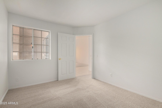 empty room featuring carpet floors and baseboards