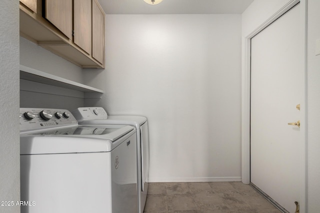 laundry area featuring washer and dryer, cabinet space, and baseboards