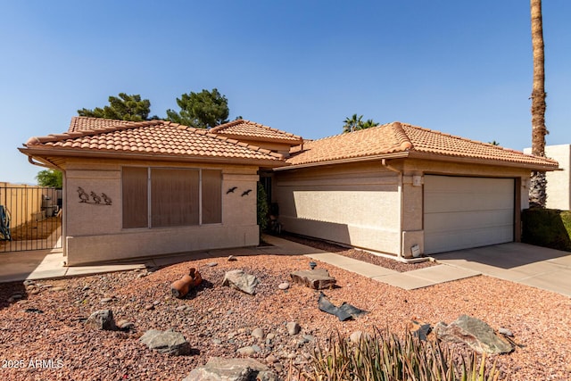 view of front of home with a tile roof, concrete driveway, and stucco siding