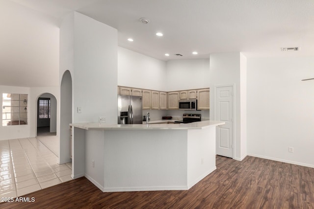 kitchen with arched walkways, high vaulted ceiling, visible vents, light countertops, and appliances with stainless steel finishes