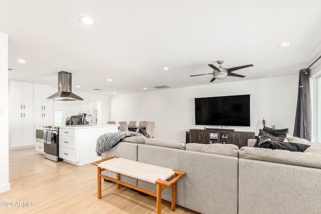 living room with ceiling fan and light hardwood / wood-style flooring