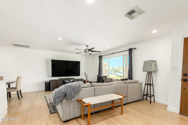 living room with ceiling fan and light wood-type flooring