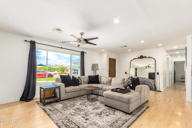 living room with ceiling fan and light hardwood / wood-style flooring