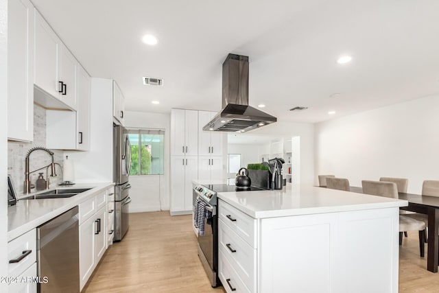 kitchen with appliances with stainless steel finishes, extractor fan, sink, light hardwood / wood-style flooring, and white cabinetry