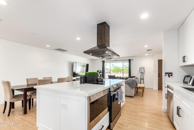 kitchen featuring stove, a center island, island range hood, and white cabinetry