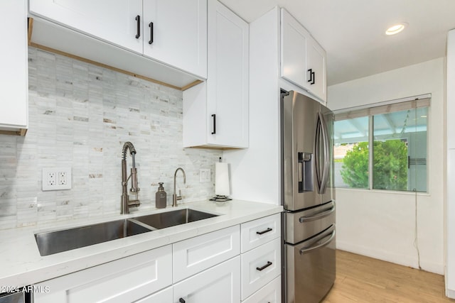 kitchen with white cabinetry, sink, tasteful backsplash, light hardwood / wood-style flooring, and stainless steel refrigerator with ice dispenser