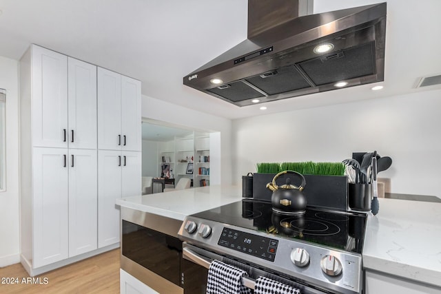 kitchen featuring white cabinetry, light stone countertops, stainless steel electric range, and ventilation hood